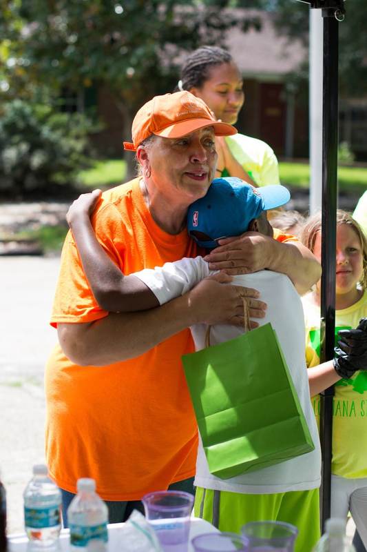 Volunteers in orange vests under a tent.