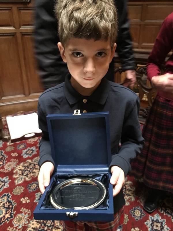 A child holding an open medal case.