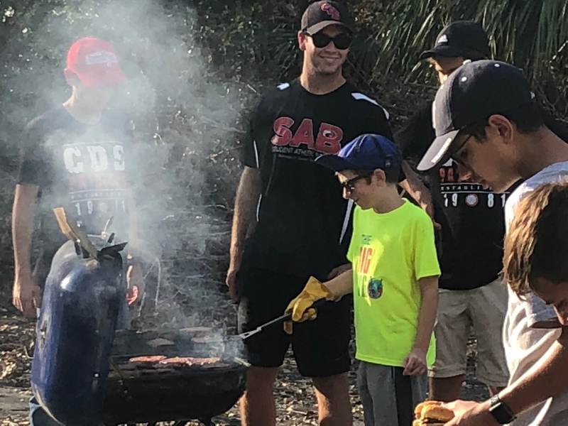 People cooking on a grill at a service day.